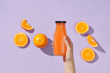 Han hold glass bottle of organic fresh orange juice with raw