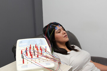 Latin adult woman is a patient in the neurology specialty office and an electroencephalogram study...