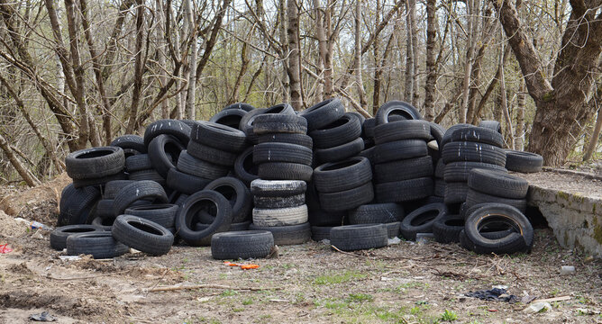 Dump of old used car rubber tires in the spring forest