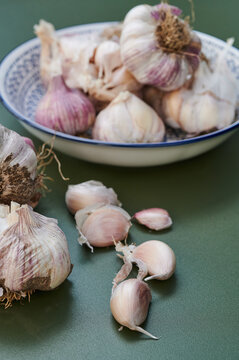 Garlic bulbs and cloves on green background