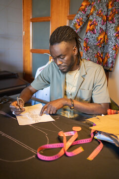 Creative Black Man Drawing Clothes In A Design Fashion Studio.