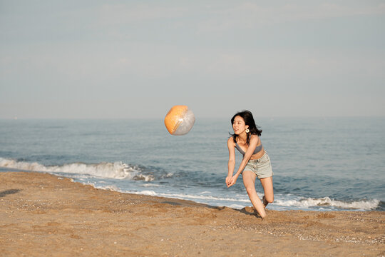 Active woman playing volleyball on the beach