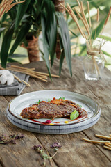 Portion of gourmet grilled beef steak on wooden background