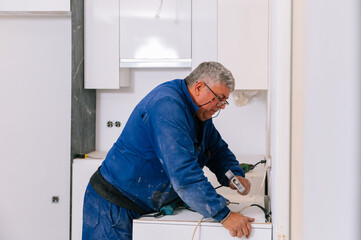 Handyman assembling furniture in new apartment with hummer