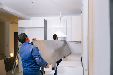 Male workers carrying countertop together