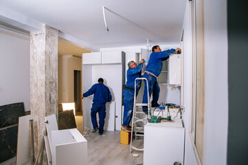 Team of workers assembling kitchen furniture