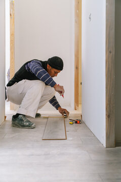 Hispanic man installing floor in new apartment