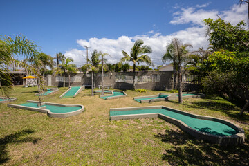 Courtyard of a vintage hotel with a mini golf course and palm trees