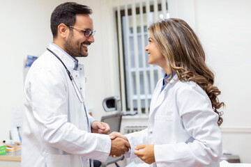 Deal! Concept of collaboration in medicine. Photo of two doctors' handshake in hospital