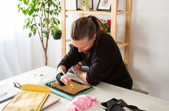 Artist works on digital design on a tablet
