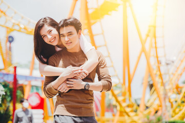 Portrait Asian couple lover happy outdoors at amusement park holiday activity together with copy...