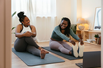 Black mom and daughter exercising at home together