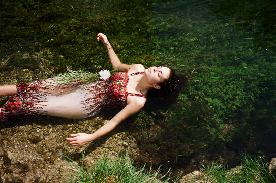 A beautiful woman lying on a back in a river