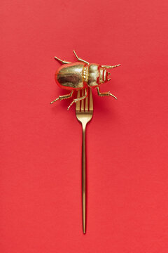 Golden set with metal bug on a fork.