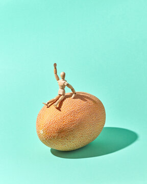 Energy wooden mannequin are siting and waving on a melon.