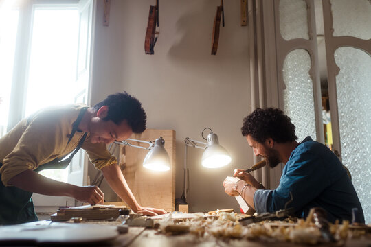 Two violin luthiers at work with happy mood