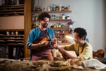 Violin luthiers having fun working at workshop