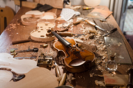 Violin on luthier's table with construction materials