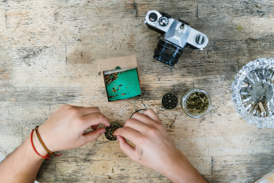 View from above of hands rolling a joint
