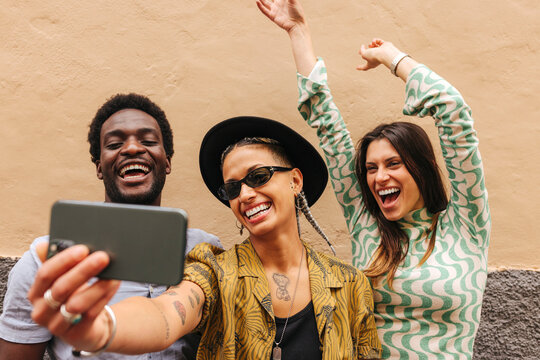 Cheerful diverse friends taking selfie