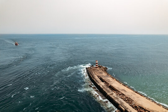 Aerial shoot of boat arriving to pier in a blue ocean water - Powered by Adobe