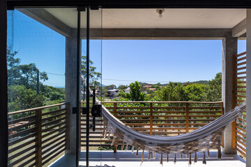 The veranda of a Brazilian house with a modern design and a hammock