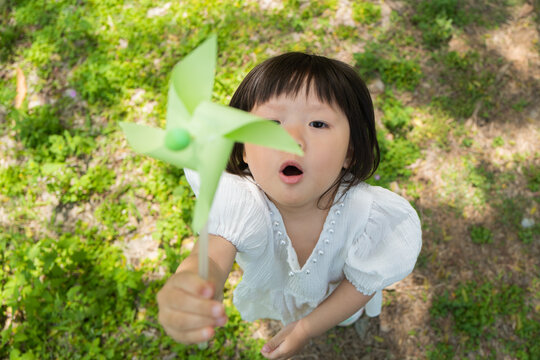 Little kid holding windmill in hand