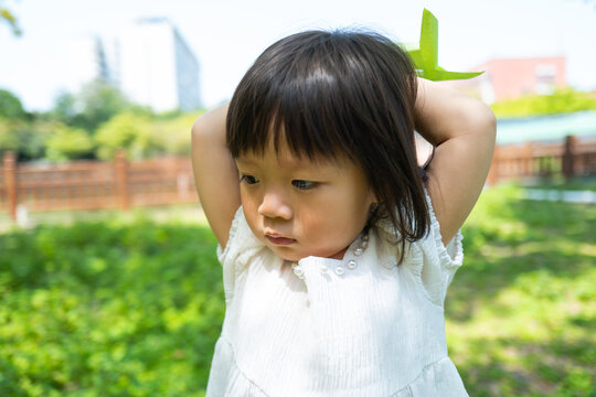 Little Kid Holding Windmill In Hand