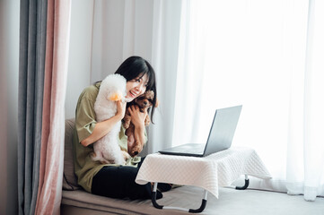 Young woman using laptop with her pet dogs