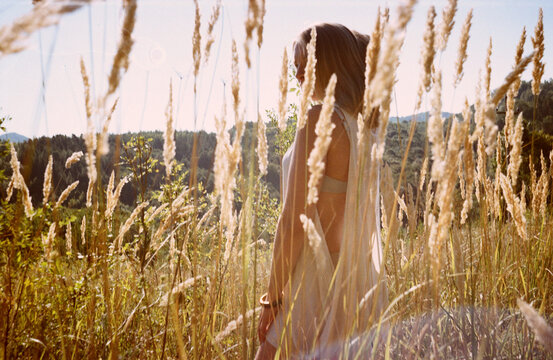 Blonde woman hiding in a summer grass
