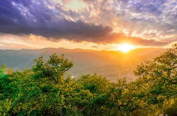 graet highland landscape with scenic view from mountain to below to a walley with majectic mountains and scenic cloudy sunset on background