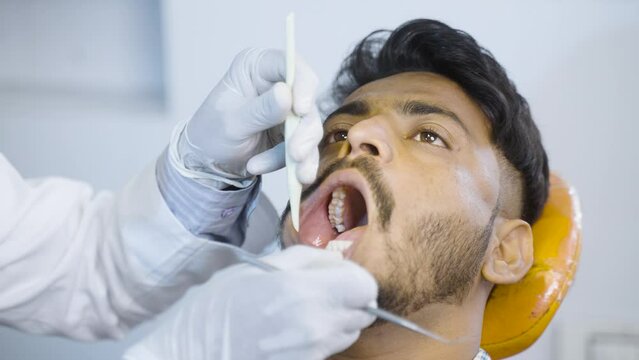 close up shot of dentist with surgical gloves checking teeth of patient at hospital or clinic - concept of oral care, treating toothache and professional occupation.