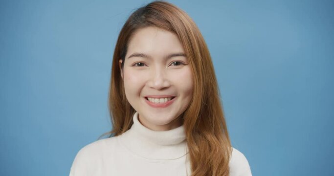Close-up youth attractive cheerful Asia lady smile looking at camera with glad expression expresses good emotions stand isolated over blue background. Happiness life pictures, Copy space concept.