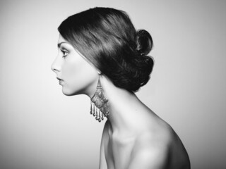 Black and white fashion art studio portrait. Photo of beautiful young woman with earring. Elegant...
