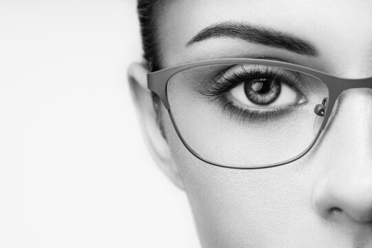 Female eye with long eyelashes in eyeglasses. Model in glasses. Vision correction. Poor eyesight. Spectacle frame. Makeup, cosmetics, beauty. Close up, macro