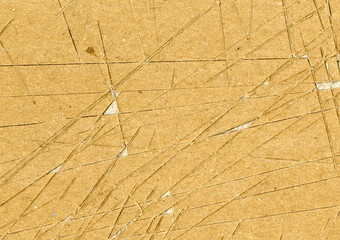 Small: Highly detailed close up brown paper board texture with many knife cut marks and scratches worn down, used grunge fine grain layered cardboard with torn surface for wallpaper design