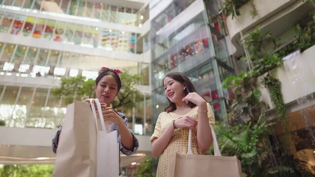 Young stylish girl friends in well dressed hang out at beautiful modern decorated department store. Happy excited shopper enjoy summer sales membership privilege. Urban Lifestyle. Female Friendship