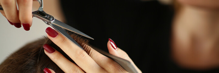 Female master put hair together and cut with scissors tool