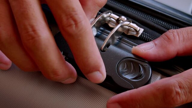 close up hand man close suitcase with combination lock.