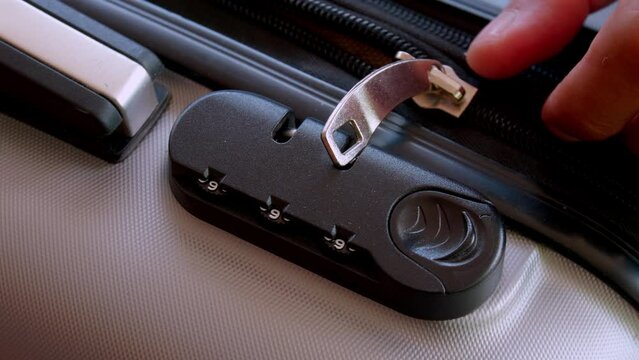 close up hand man close suitcase with combination lock.