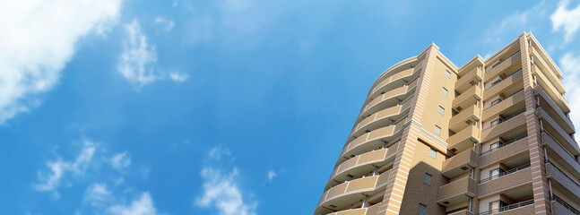 真っ青な大空と新築マンションのパノラマ背景素材