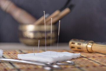 Cork coaster with acupuncture needles on black table, closeup. - obrazy, fototapety, plakaty