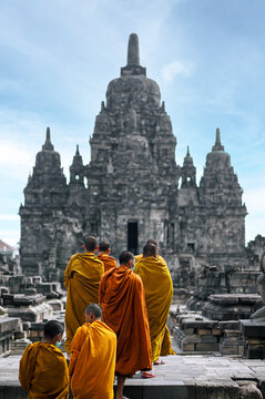 Front view of Sewu Temple, with Buddhists wearing orange robes from back. Candi Sewu, Buddhists in the temple. Unesco, world heritage. Prambanan, Central Java, Yogyakarta, Indonesia. Selective focus.