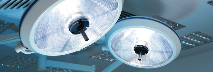 Powerful surgical lamps in modern operating room, closeup. Banner design