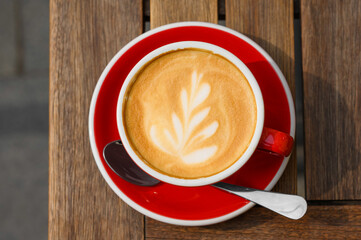 Cup of aromatic coffee on wooden table, top view