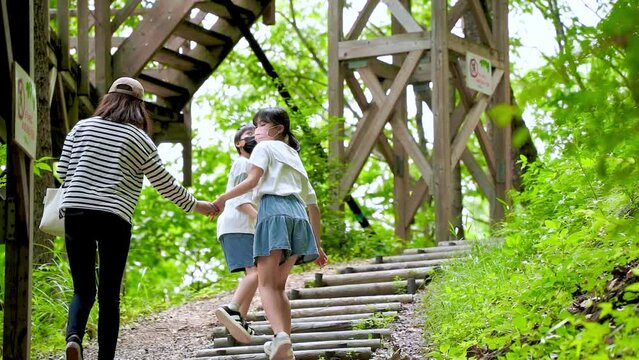 自然の中を歩くアジア人の親子