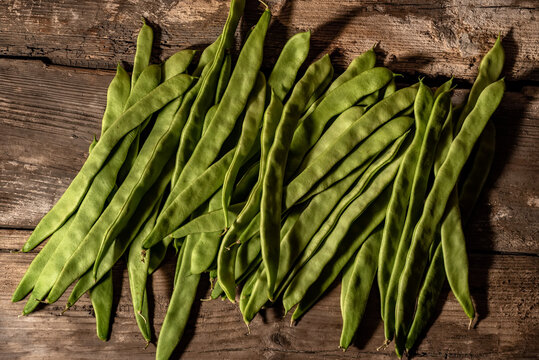 Fresh green beans Phaseolus vulgaris on old wooden background.