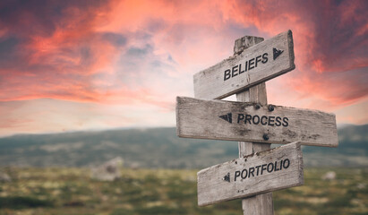 beliefs process portfolio text quote caption on wooden signpost outdoors in nature with dramatic sunset skies. Panorama crop. ESG Concept - obrazy, fototapety, plakaty