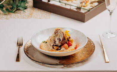 Meat roll with prunes is served on a pillow of vegetables and rice in restaurant