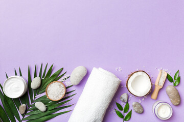 Obraz na płótnie Canvas Coconut with jars of coconut oil and cosmetic cream on colored background. Top view. Free space for your text. Natural spa coconut cosmetics and organic treatment concept Coconut Spa composition